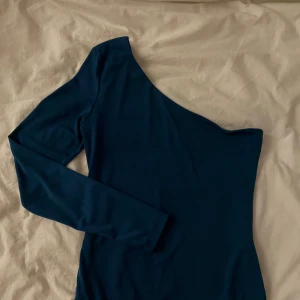 Body  - Mörkgrön/blå body från Nelly med en arm, string vid fästet dvs ingen tros kant! 🤍