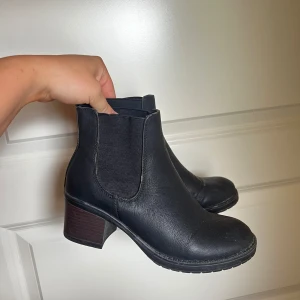 Svarta Chelsea boots med klack - Säljer ett par snygga svarta Chelsea boots i skinn. De har en bekväm klack och elastiska paneler på sidorna för enkel på- och avtagning. Perfekta för både vardag och fest! defekt finns (se bild)