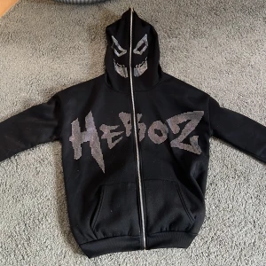 Heroz hoodie - Väldigt bekväm och mjuk hoodie som inte kommer till användning då den är lite för stor på mig. Fullzip med fett ansikte. Inga stenar saknas