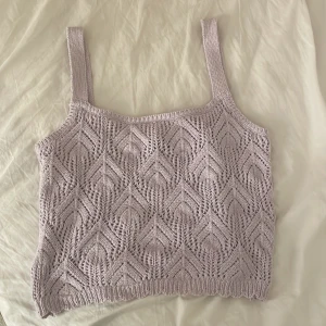Virkad topp - Ljuslila virkad topp från Lindex. Aldrig använd så den är som ny fast utan prislapp. Den slutar ungefär vid naveln. 