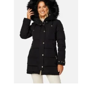 Svart vinterjacka med pälshuva - Säljer en snygg och varm svart vinterjacka med en fluffig pälshuva. Jackan har långa ärmar och stängs med både dragkedja och knappar. Perfekt för kalla vinterdagar! Använd två vintrar och har tyvärr blivit för liten för mig därav säljer jag den:(