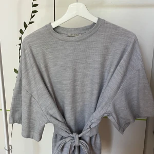 T-shirt med knyt - Så snygg tröja från Zara med band i midjan.  Bra skick, dock är det en fläck på ena bandet (se sista bilden) Storlek S men sitter oversized på mig som är en S/M