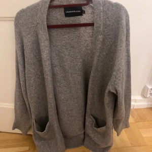 Stickad cardigan - Skitsnygg Calvin Klein cardigan. Helt ny och oandvänd. I strl L men passar även fint på S och M.