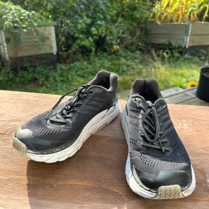 Löparskor från Hoka - Svarta löparskor från Hoka. Modell Clifton 6. Välanvända men valbevarade så i gott skick. Finns en del slitage (se bild) 