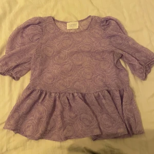 Lila blus från Sisters Point - Säljer en söt lila blus från Sisters Point (Salt)  med puffiga kortärmar och volangdetaljer. Passar bra till både jeans och kjol. 💓