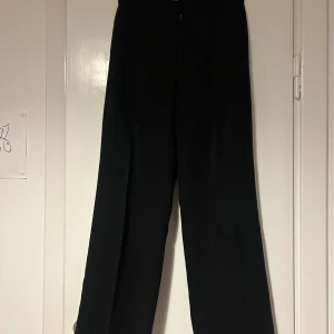 Svarta kostymbyxor från Filippa K - Snygga svarta kostymbyxor från Filippa K med en elegant och stilren design. Byxorna har en hög midja och en wide passform. Otroligt bra kvalité! Inköpta för ca 2500 kr. 