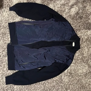 Blå Cardigan från John Henric - Snygg blå cardigan från John Henric. Jackan har dragkedja framtill och är perfekt för en snygg och avslappnad stil. Passar bra till både jeans och chinos. Nypris: cirka 1200kr