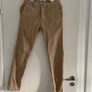 Beige chinos från NN07 - Snygga beige byxor från NN07 med en stilren design. Passformen är normal