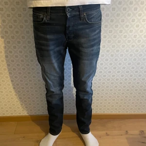 Mörkblå jeans från Jack & Jones - Snygga mörkblå jeans från Jack & Jones med en klassisk femficksdesign. De har en slim passform och är tillverkade i ett stretchigt denimtyg för extra komfort. Perfekta för en stilren look. Storlek W28 L30 och modell Slim Straight/Tim. Om du har någon som helst fundering är det bara att fråga. Mvh Levi!