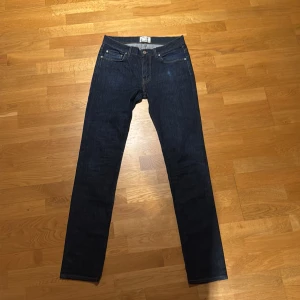 Mörkblå jeans från Acne Studios - Snygga mörkblå jeans från Acne Studios med klassisk femficksdesign och knappgylf. De har en rak passform och är perfekta för en stilren look. Passar till många olika outfits och tillfällen. Byter gärna. 