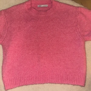 Rosa stickad tröja från Zara - Säljer en mysig rosa stickad tröja från Zara. Tröjan har en rund halsringning och ribbade kanter vid ärmslut och nederkant. Perfekt för sommaren när man är brun till typ en blå jeans kjol❤️❤️Storleken är M, men jag bär normalt sätt xs och den sitter perfekt på mig.