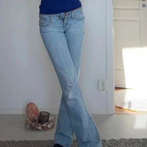Ljusblå bootcut jeans - Säljer mina lågmidjade jeans, midjemått:36cm innerbenslängd:80cm