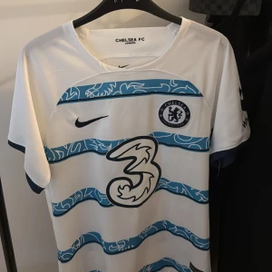 Chelsea FC matchtröja 2022/2023 (med tryck) - Chelsea FC fotbollströja (S) 2022/23. Tröjan har tryck där bak därav lägre pris men annars jätte fräsch!