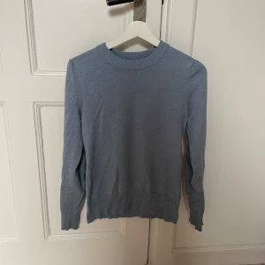Stickad tröja från Saint Tropez - Säljer en stilren ljusblå finstickad tröja från Saint Tropez i storlek XS. Tröjan har en rund halsringning och långa ärmar med ribbade muddar vid ärmslut och nederkant.