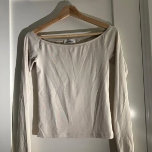 Beige långärmad topp från Gina Tricot - Säljer en stilren beige långärmad topp från Gina Tricot. Toppen har en enkel design med en rund halsringning och är perfekt för lager-på-lager. Passar bra till både jeans och kjol. Perfekt basplagg för garderoben!