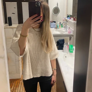 Beige stickad tröja - Säljer en stilren beige stickad tröja med trekvartsärm. Perfekt för en avslappnad look och enkel att matcha med olika outfits. Tröjan har en lös passform som ger en bekväm känsla. Passar bra till både jeans och kjol.