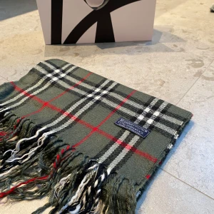 Burberry halsduk  - Hej, nu säljer jag en burberry scarf perfekt skick inga tydliga defekter på användning. Den är äkta men inget kvitto eller något följer med tyvärr. Halsduken är i materialet: 100% Kashmir. Normal i storleken och passar perfekt till alla. Pris går att diskutera vid snabb affär. Skriv till mig vid minsta lilla funderingen 😊, Mvh