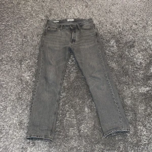 Grå jeans från Jack & Jones - Snygga grå jeans från Jack & Jones i modellen Relaxed/Chris. Passar runt 175-180. Storleken är 28-30. Några små defekter som dock inte syns. Nypris 600, mitt pris 250(inte hugget i sten) hör av dig vid minsta fundering! 