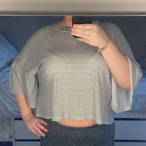 Randig croppad topp - Säljer en randig croppad topp med korta ärmar. Toppen är ifrån Monki och är i storlek M, använd endast fåtal gånger och pris kan diskuteras.