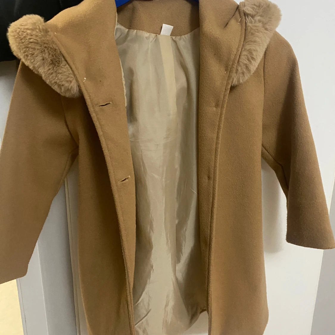 Beige kappa med pälsdetaljer