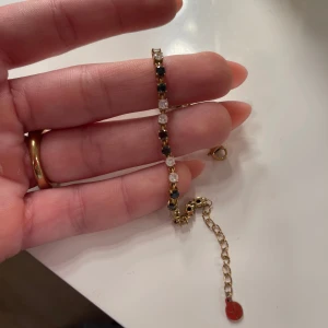 Tennisbracelet Edblad  - Tennisbracelet Edblad med vita och svarta stenar. Guldig. Helt nytt. 