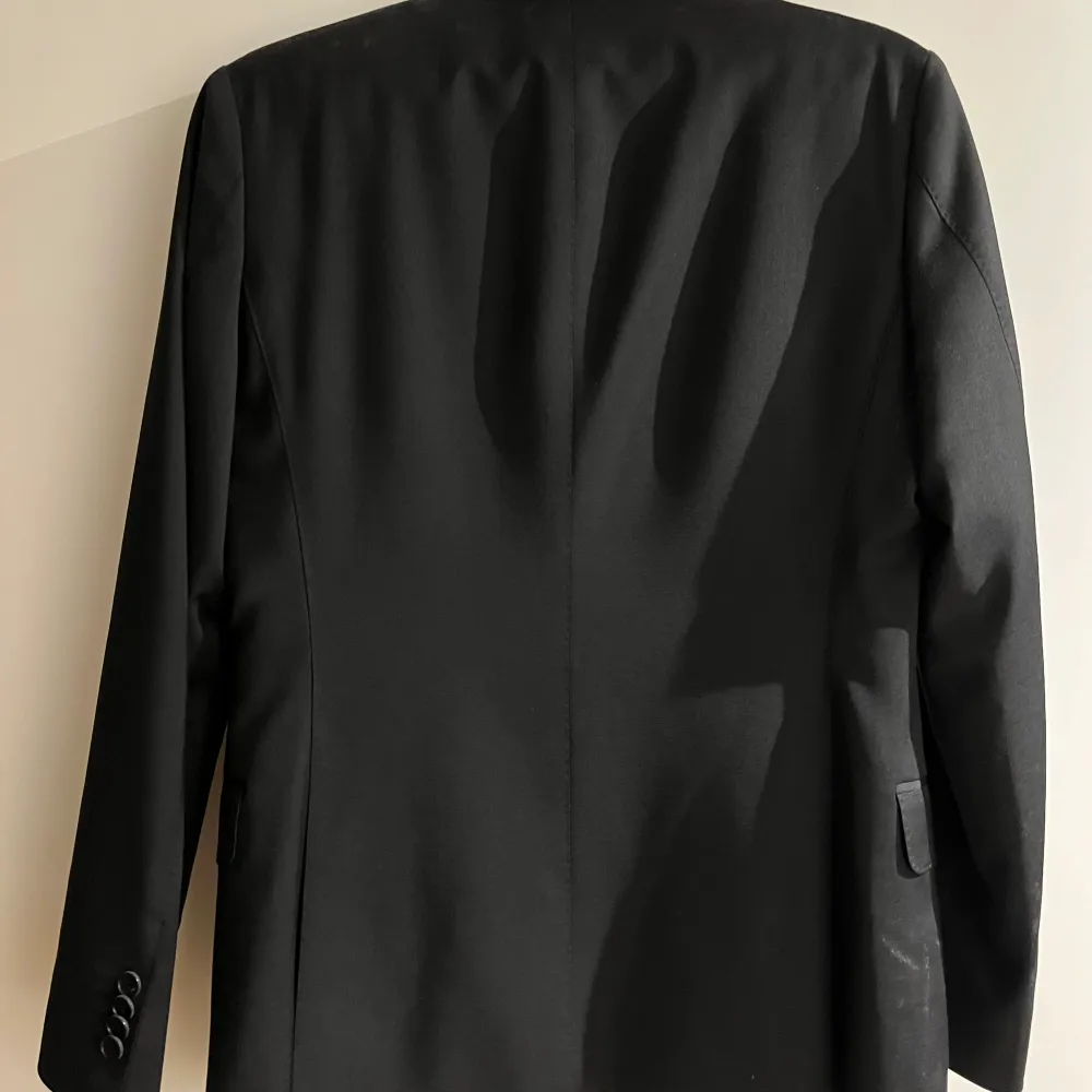 Svart kostym byxor och kavaj från Oscar Jacobson, perfekt för formella tillfällen. Använd en gång på en bal. Nypris 6000kr mitt pris 3999kr. Puvut & Bleiserit.