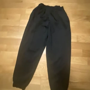 Svarta mjukisbyxor - Säljer ett par bekväma svarta mjukisbyxor med elastisk midja och muddar vid bensluten. Perfekta för en avslappnad dag hemma eller en promenad i parken.