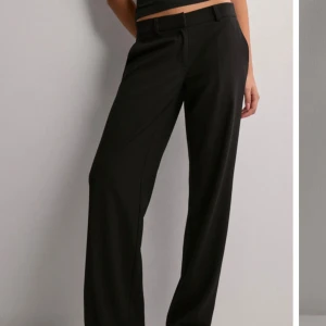 Lågmidjade kostymbyxor - Snygga svarta kostymbyxor med låg midja och rak passform. De är två trådar på två ställen som knappt syn men lågt pris pga av de. Säljer pga av för små och därför ingen andvändning. Kan antingen möttas i Stockholm eller !köparen står för frakten!