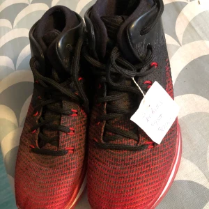 Svart och röda sneakers - Snygga svart och röda sneakers från Jordan med snörning. Skorna har en stickad look och en röd sula som ger ett sportigt intryck. Perfekta för dig som vill ha en stilren och bekväm sko.