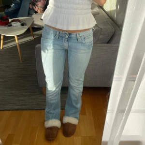 Ljusblå jeans med bootcut - Snygga ljusblå jeans med bootcut-stil och låg midja. Perfekta för en avslappnad look. De har klassiska fem fickor och en knappgylf. Midjemått💞39 o innerben 81