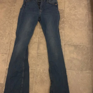 Blå flare jeans från &Denim - Snygga blå flare jeans från &Denim med hög midja. Perfekta för en trendig look med sin klassiska jeansstil och bekväma passform.