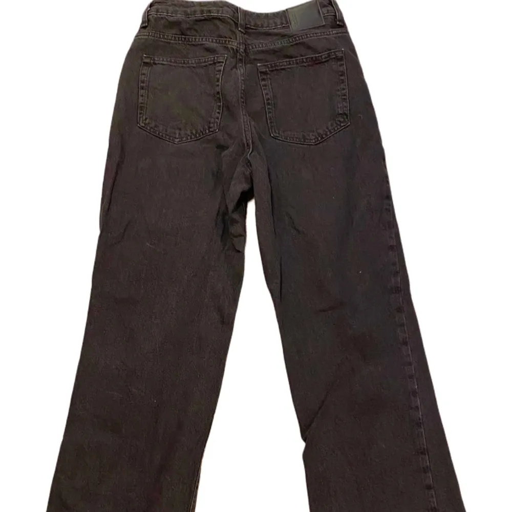 svarta jeans med en bred passform och regular waist. Midjemått är 28 och längd 34. Klassisk design med fem fickor och knappgylf.. Farkut & Housut.