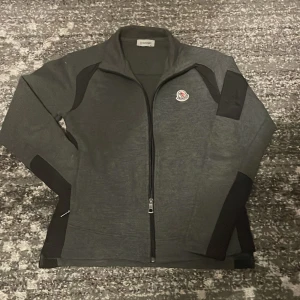 Grå Moncler zipup - Säljer en grå moncler zip up i storlek M barn. Sitter som en XS. Om du har en fråga är de bara fråga svara på alla 🤩
