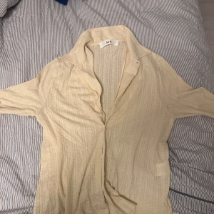 Gul skjorta från Sefr - Snygg gul skjorta från Sefr med klassisk krage och långa ärmar. Skjortan har en diskret randig textur och är perfekt för en stilren look. Passar bra till både jeans och kostymbyxor. Knappt använd, inga tecken på användning . Storlek M/ L nypris 2000 kr på NK.