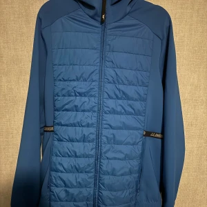 Blå cardigan från J.Lindeberg - Snygg blå cardigan från J.Lindeberg med dragkedja och quiltad design. Riktigt fet strl L passar M vid frågor bara skriv