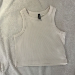 Vit linnetopp från H&M Divided - Säljer en vit ribbad linnetopp från H&M Divided. Aldrig använd. Storlek XS.