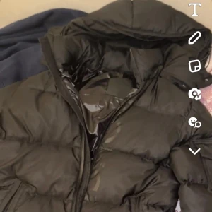 Moncler jacka - Säljer en svart moncler jacka i mycket bra skick. Den har en glansig finish och en praktisk huva. Jackan är perfekt för kalla dagar och har en dragkedja framtill. Den har också en ficka med knappdetalj på ärmen. Supermysig och varm! Storlek 3 vilket passar M-S. Den har ett litet problem och det är att det finns ett litet hål i vänstra fickan men sakerna ramlar inte ner de blir ba lite lite djupare in så det är nog inga problem. Pris går och diskutera vid snabbaffär. Jag är redo för byte också!