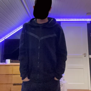Svart Nike tech fleece hoodie - Säljer en svart Nike tech i bra skick. Den har en dragkedja framtill och en bekväm huva. Perfekt för höst och vår, eller bara för att chilla hemma.      Kan ändra pris vid snabb affär och tar emot byten 