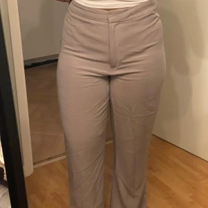 Beige kostymbyxor - Säljer ett par stilrena beige kostymbyxor i mycket bra skick. De är högmidjade och har en straight passform som ger en klassisk look. Perfekta för både kontoret och mer formella tillfällen. Materialet är super mjukt och bekvämt mot huden. Säljer då dem tyvärr är för stora/för långa för mig.