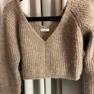 Beige stickad tröja från Gina Tricot - Säljer en beige brun stickad tröja från Gina Tricot. Den är croppad med v-ringning och långa ärmar. Använd fåtal gånger, pris kan diskuteras🩷