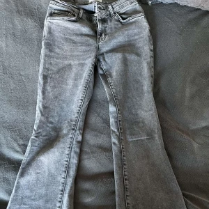 Grå bootcut jeans från Pieces - Säljer ett par snygga grå bootcut jeans från gina i storlek 36. Perfekta för både vardag och fest! 🖤
