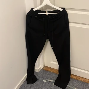 Svarta byxor från Boss - Säljer ett par stilrena svarta byxor från Boss. De har en snygg och enkel design med snörning i midjan och en liten logga på baksidan. Perfekta för både vardag och fest. Byxorna är i mycket bra skick och passar till alla tillfällen. Fick dessa av en vän.