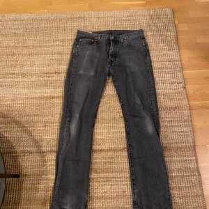 Svarta Levis 501 jeans - Säljer ett par klassiska svarta Levis 501 jeans. De har en straight passform. Perfekta för både vardag och fest. Dragkedja och knappstängning framtill med fem fickor. Litet hål vid skrevet men går enkelt att sy dit.