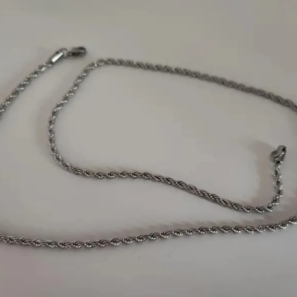 Snyggt silverfärgat halsband med en tvinnad design som ger en stilren och modern look. Perfekt för både vardag och fest. Halsbandet är enkelt men elegant och kan matchas med olika outfits för att ge en extra touch av stil. KOM KÖP DEN NU!!. Accessoarer.