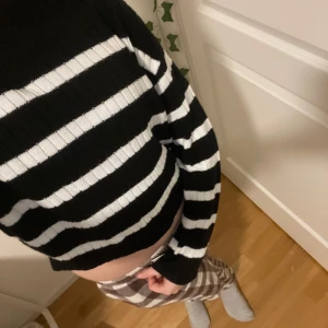 Svart och vit randig croppad tröja - Säljer en superfin svart och vit randig tröja som är croppad och perfekt för en avslappnad stil. Den är ribbad och har långa ärmar, vilket gör den både bekväm och trendig. Passar perfekt till höst och vår!