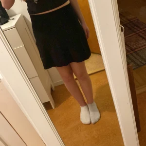 Svart kortkjol - Säljer en stilren svart kortkjol i mycket bra skick. Perfekt för både vardag och fest! Kjolen har en enkel design utan mönster eller detaljer, vilket gör den lätt att matcha med olika toppar. Passar bra till sommarens alla tillfällen. 