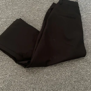 Svarta byxor från BikBok - Säljer ett par svarta byxor från BikBok i storlek 38. De har en klassisk design med dragkedja och knapp framtill. Perfekta för både vardag och fest! 🖤