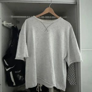 Kortärmad sweatshirt  - Säljer en grå loose tröja med korta ärmar och rund hals. Perfekt för en avslappnad stil och passar bra till vardags. Tröjan har en enkel design med en liten detalj vid halsen💕💕💕