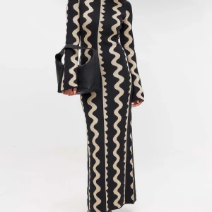 Svart och beige stickad långklänning med mönster - Säljer en supercool svart långklänning med ett unikt vågigt mönster i beige. Klänningen har långa ärmar och en tight passform som verkligen framhäver figuren. Perfekt för höst och vinterfester! 🖤✨ Från NA-KD inte använd många gånger. Nypris 799kr