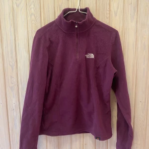 Lila fleece från The North Face - Säljer en supermysig lila fleece från The North Face i storlek XS. Perfekt för kyliga dagar med sin höga krage och halv dragkedja. Den är i bra skick och redo för nya äventyr! 💜